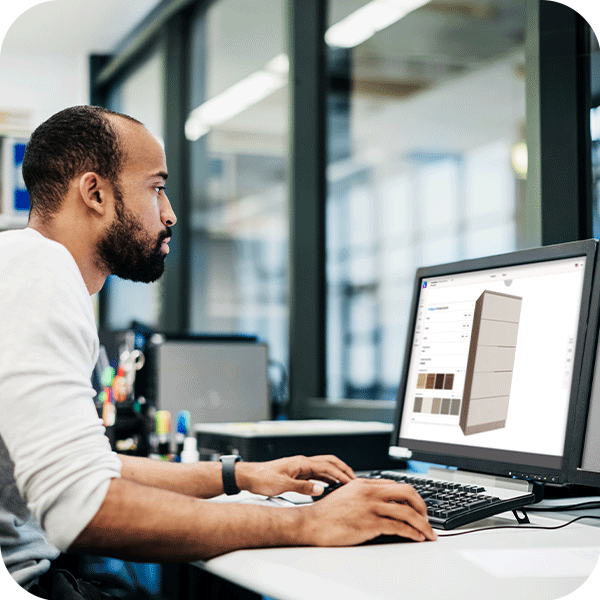 A man working at a desk, with a computer screen in front of him.