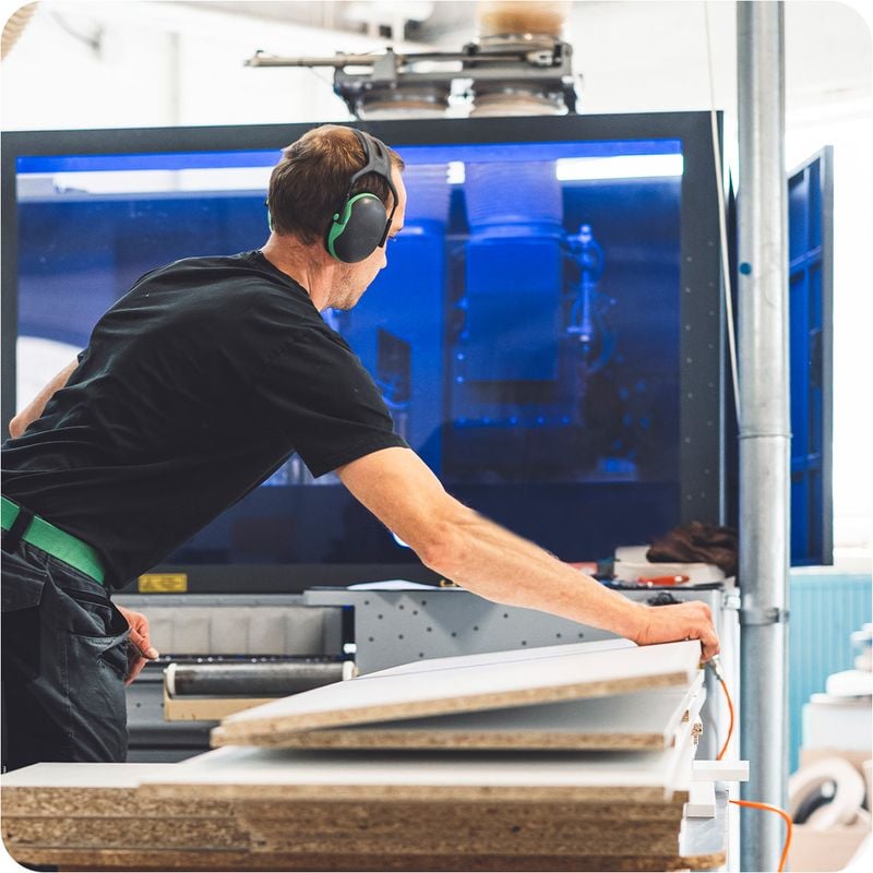 A man in a black shirt working in a warehouse.