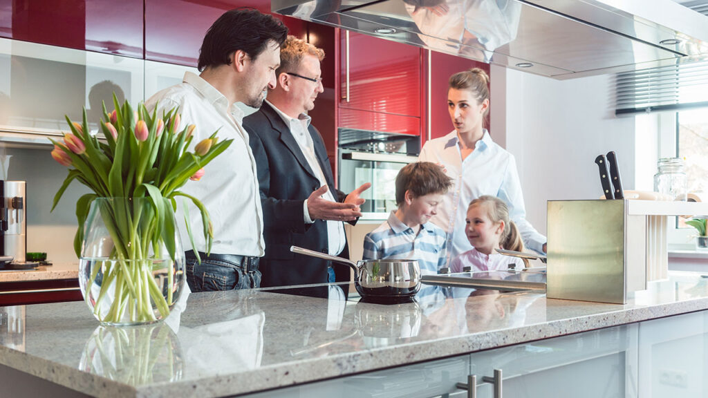 A family of four standing in a kitchen.