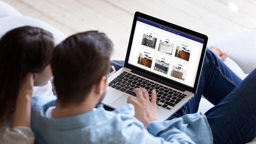 A man and woman sitting on a couch with a laptop.