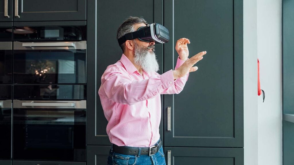 A man wearing a VR headset in a kitchen.