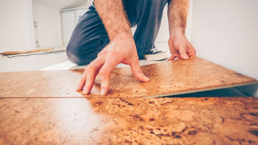 A man laying on a cork floor.