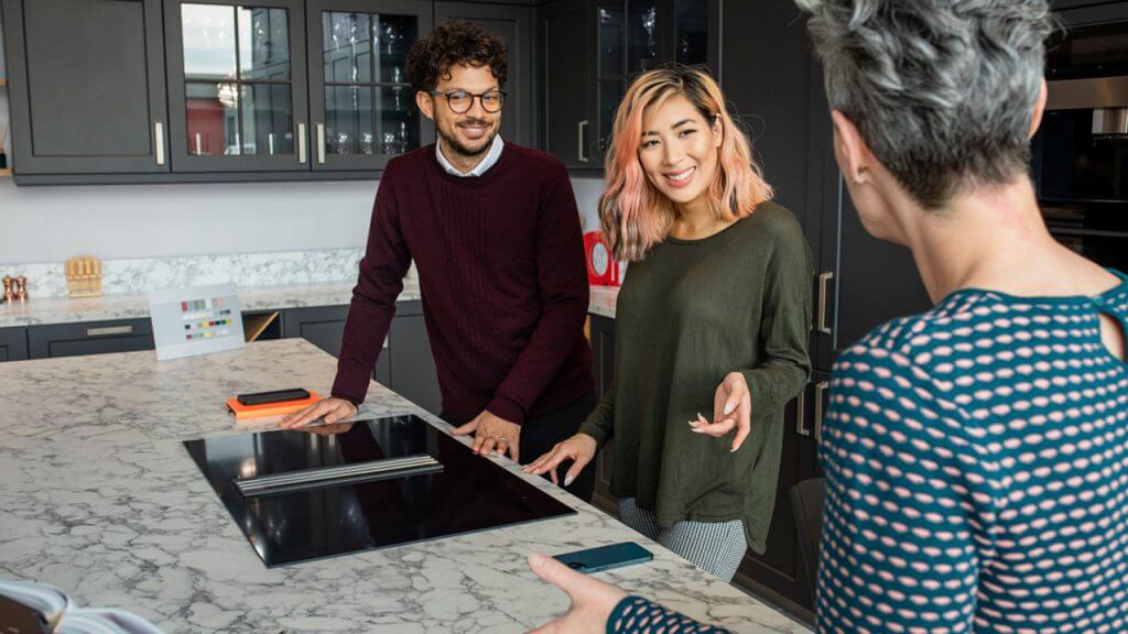 A couple in a modern kitchen showroom
