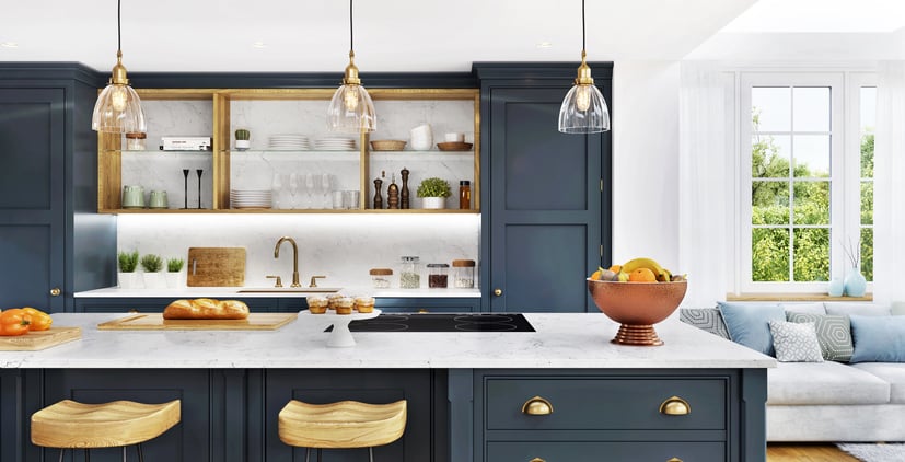 A beautifully designed kitchen with dark cabinetry, a marble countertop, and brass fixtures. The kitchen features pendant lighting, an island with wooden stools, and open shelves displaying dishes and decor.