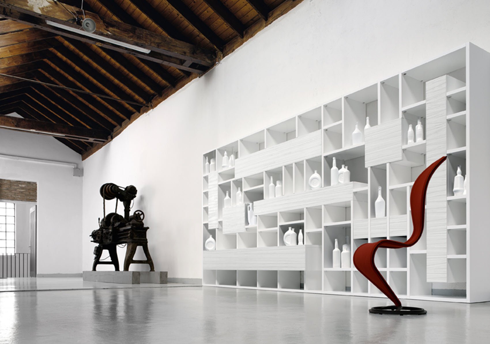 A modern interior with white shelving units filled with white decorative items.