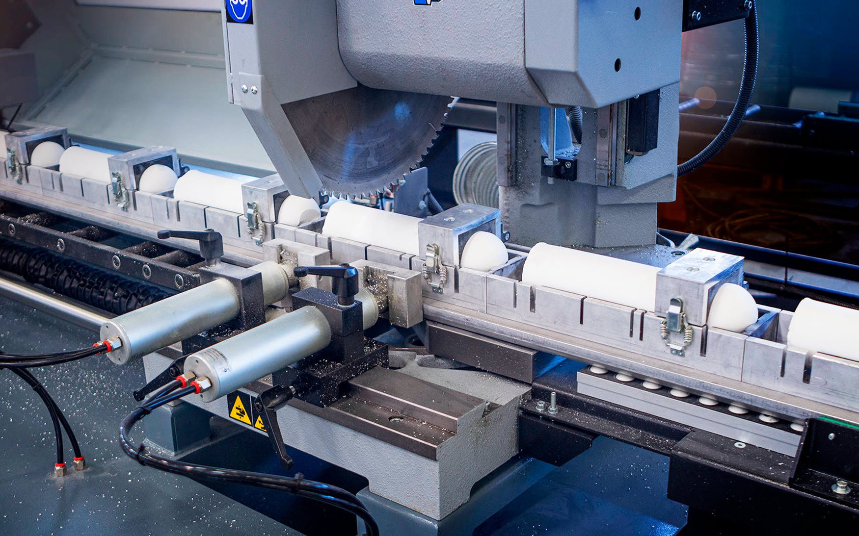 A close-up view of an industrial machine cutting cylindrical objects.