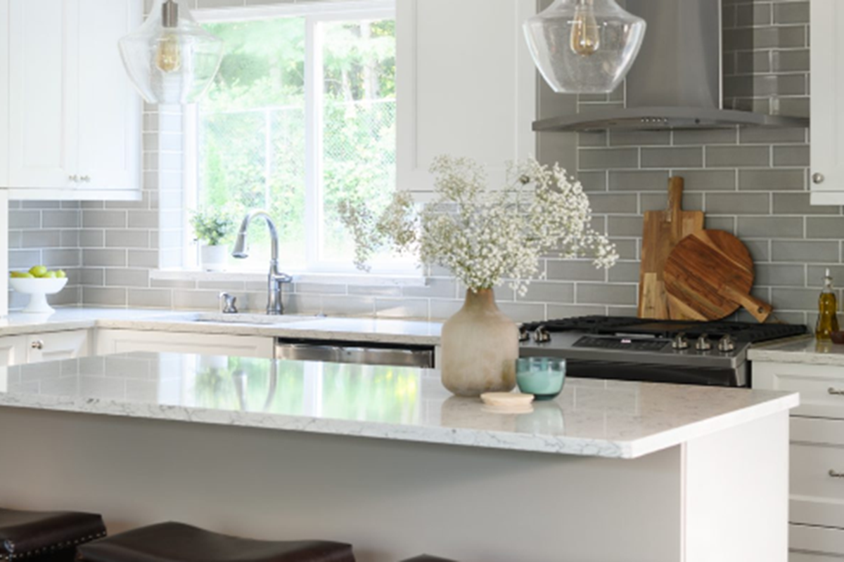 Bright and modern kitchen design created using Design Live by Justine Marie Designs. Features a white island countertop, stainless steel refrigerator, and gray tile backsplash with natural light streaming in through the window.