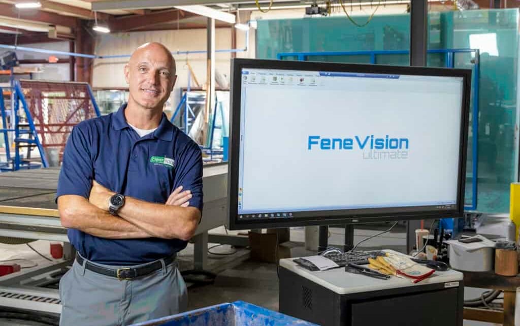 A man stands before a large screen displaying "FeneVision" logo