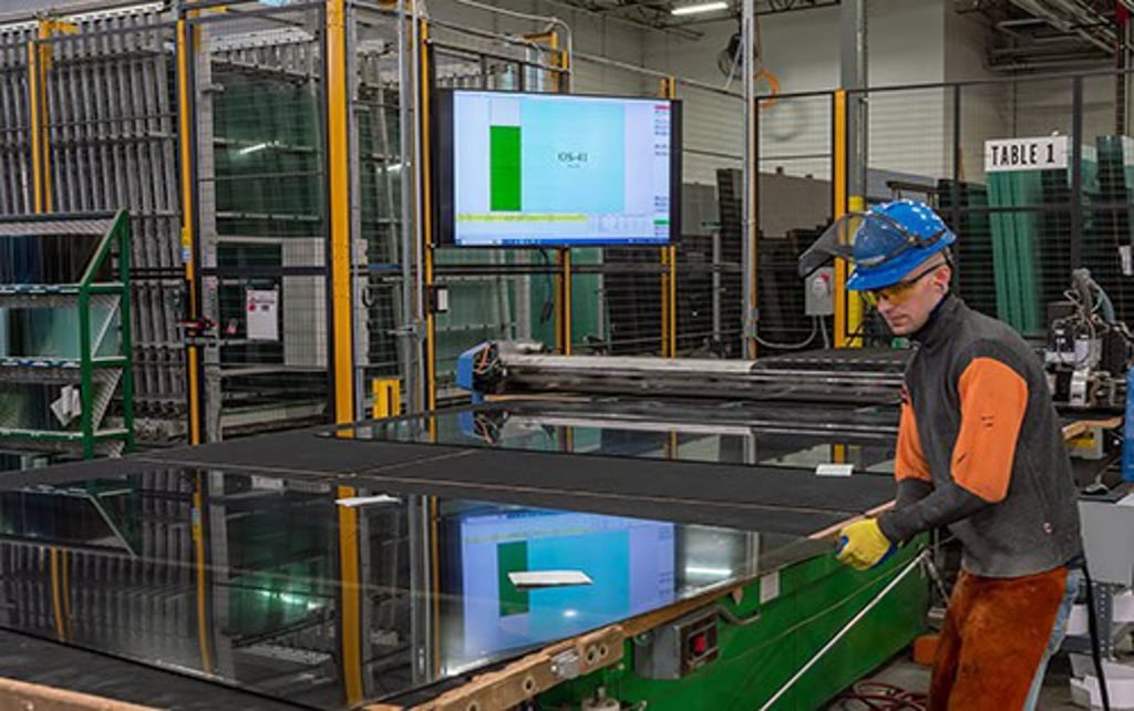 A worker focused on a large glass table