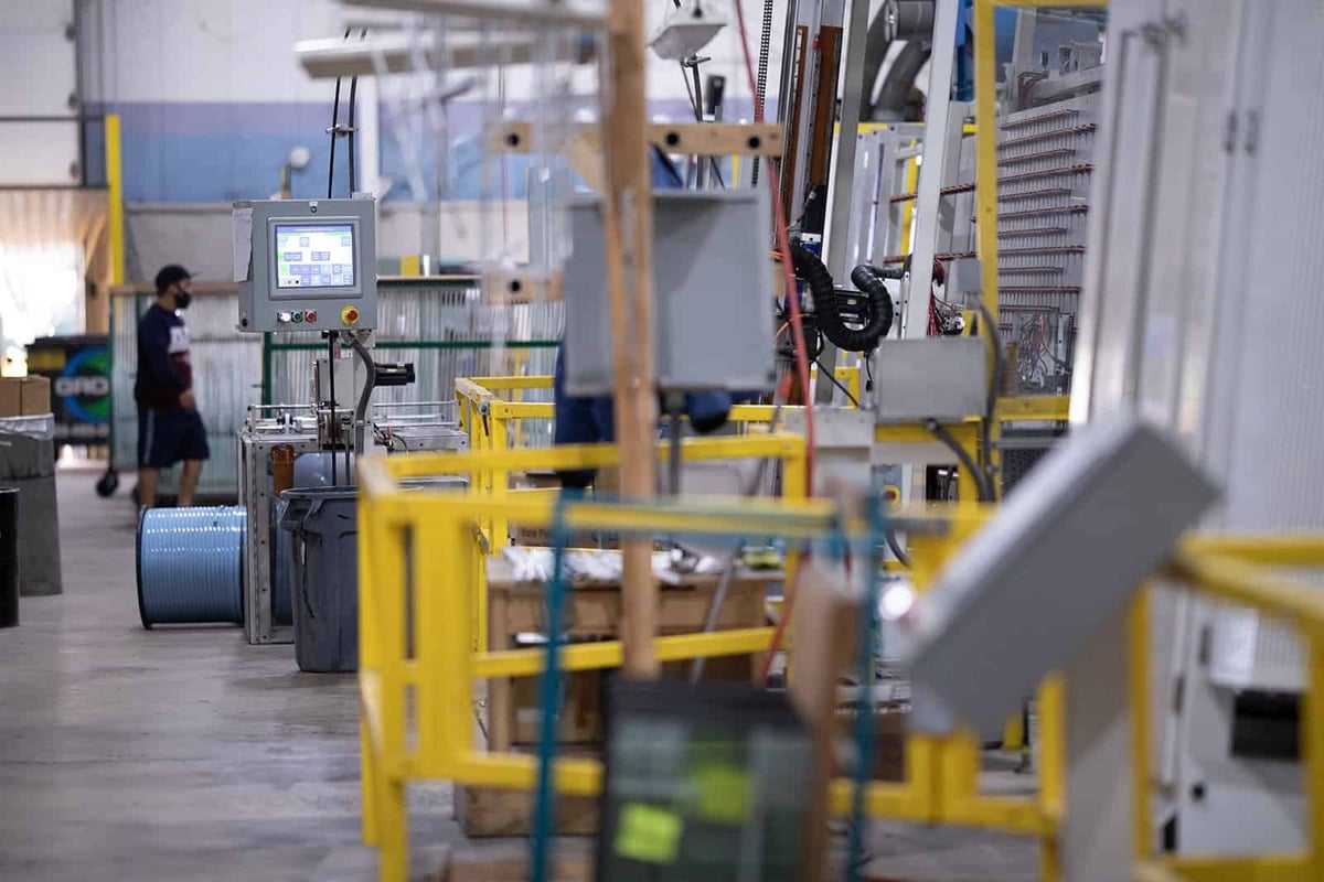 A man walks through a factory filled with various machines