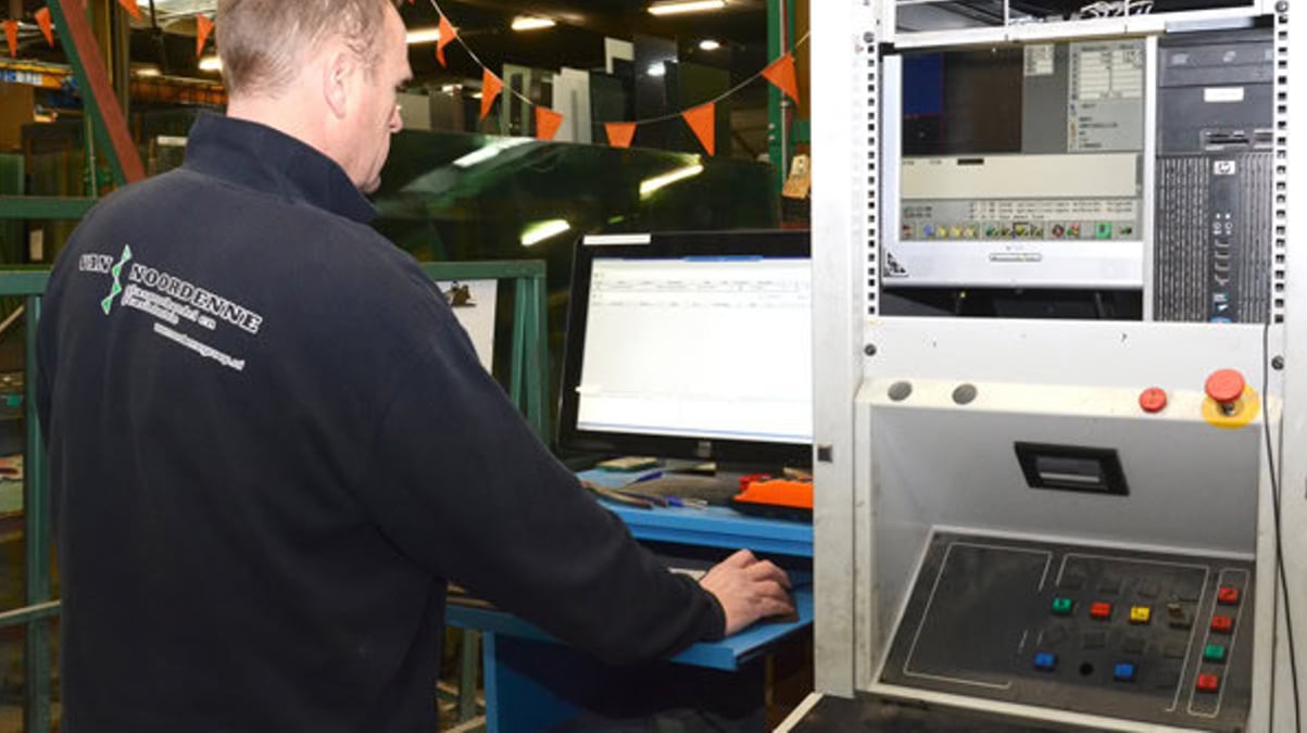 A factory worker operating a computer