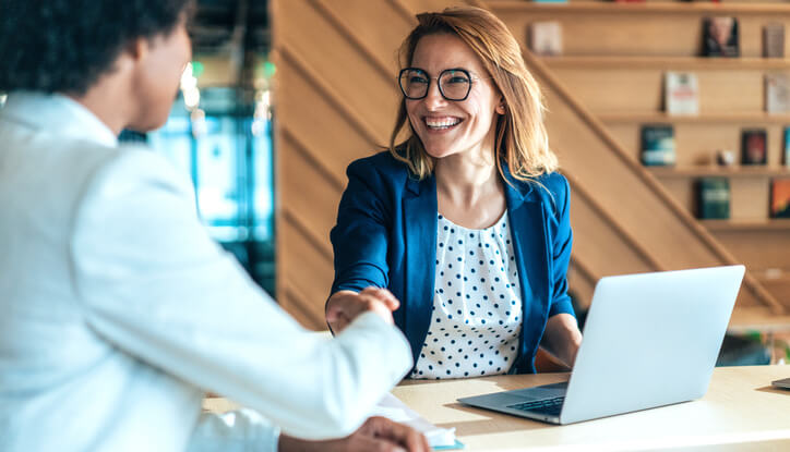 A woman and a man shake hands in a partnership