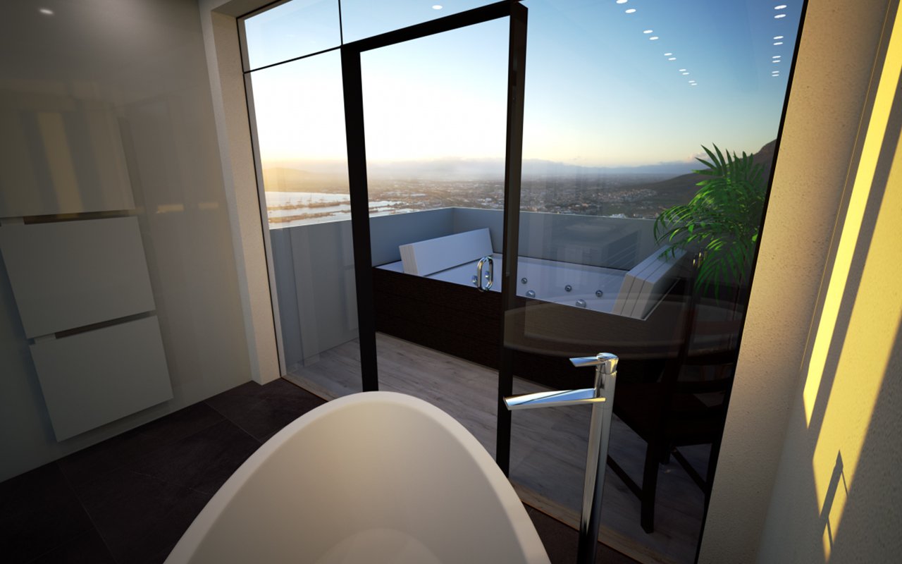 Luxury bathroom with a freestanding tub and glass doors opening to a stunning balcony view of a sunset over the city.